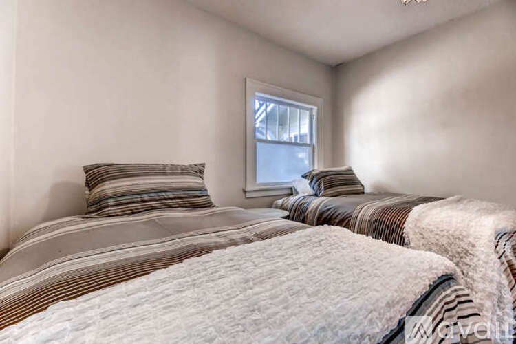 A bedroom with a bed covered in a striped comforter and two striped pillows.