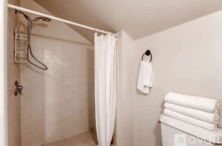 A white bathroom with a towel hanging on the hook.