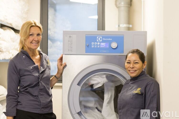 Two women are standing in front of a large industrial machine.