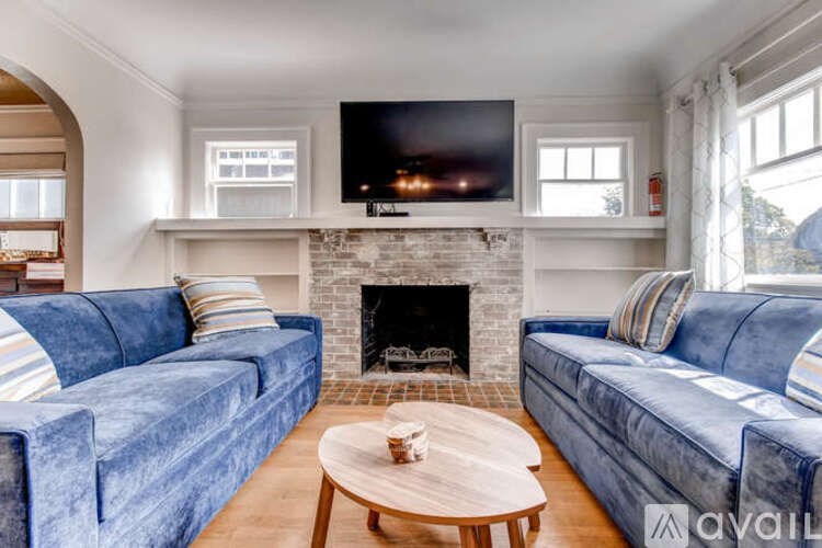 A living room with a fireplace and a television on the wall.