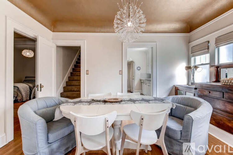 A dining room with a round table and chairs.
