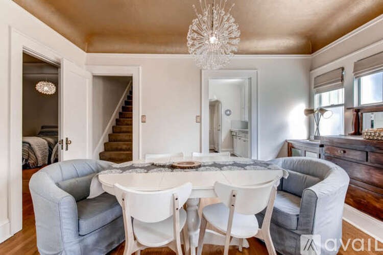 A dining room with a round table and chairs.