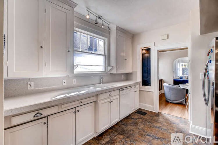 A kitchen with white cabinets and a window above the sink.