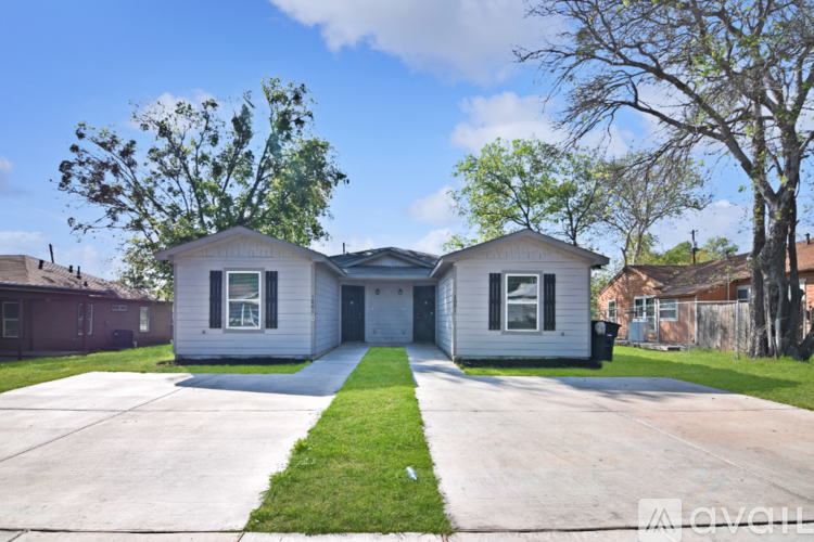 A white two-story house with a driveway in front.