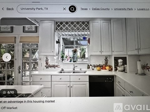 A kitchen with white cabinets and a stove top oven.