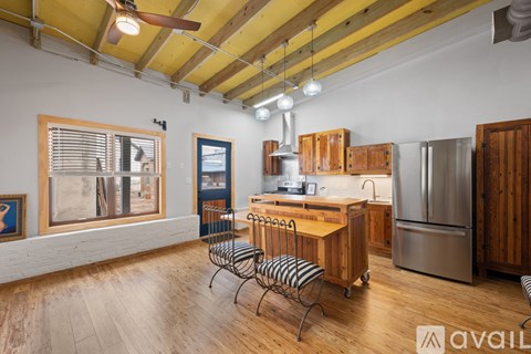A kitchen with wooden cabinets and a refrigerator.