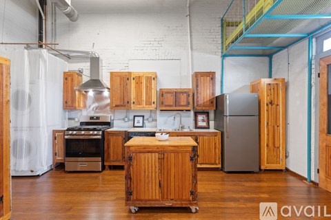 A kitchen with wooden cabinets and a stainless steel refrigerator.