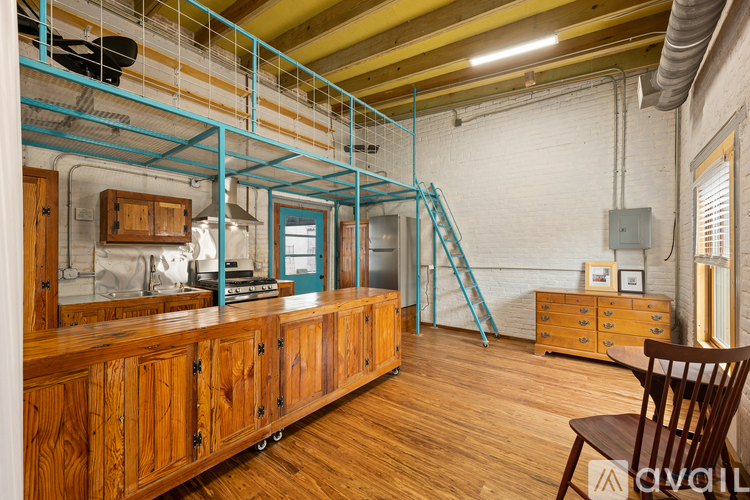 A room with wooden cabinets and a blue staircase.
