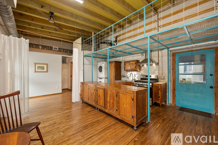 A room with a wooden floor and a blue door.