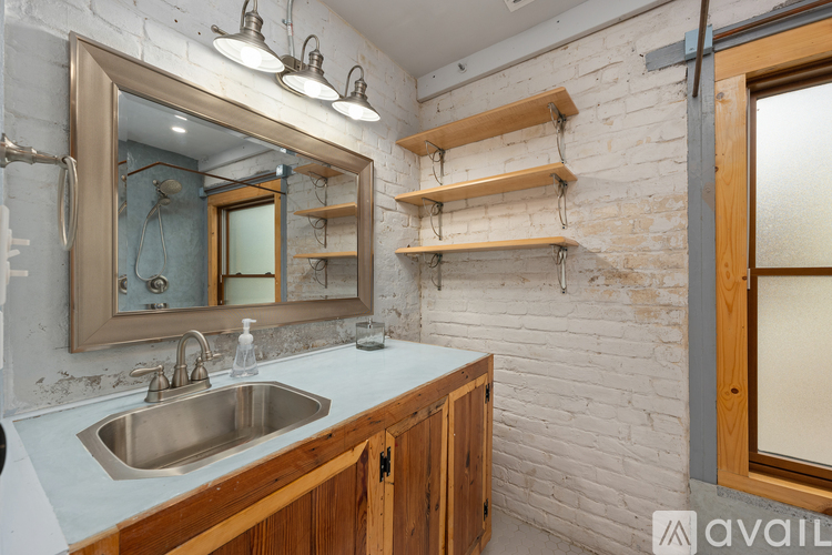 A bathroom with a sink, mirror, and wooden shelves.