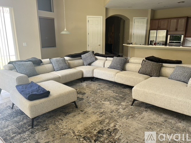 A living room with a large sectional sofa and a chaise lounge.