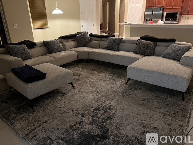 A grey sectional sofa with pillows in a living room.