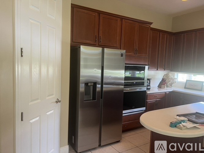 A kitchen with a refrigerator, oven, and microwave.