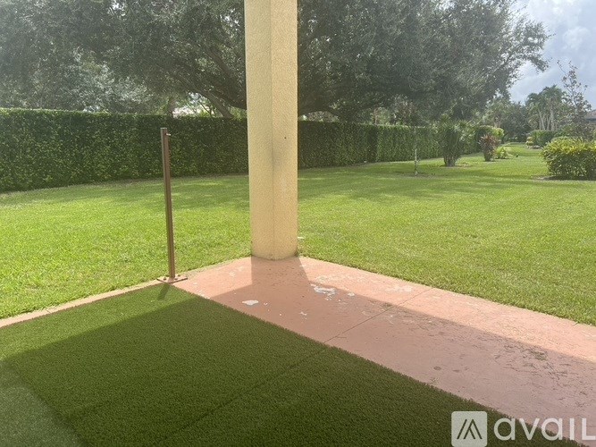A grassy area with a pole and a path.