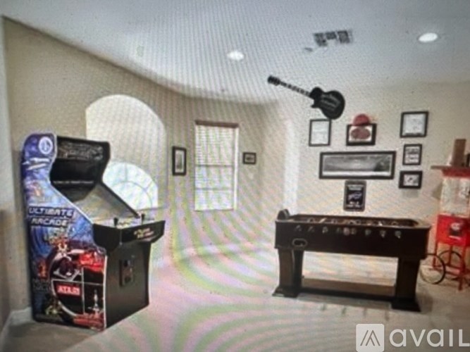 A room with a pool table, a pinball machine, and a jukebox.