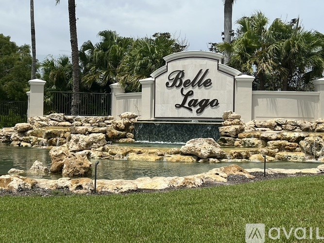 A sign that says Belle Lago in front of a waterfall.