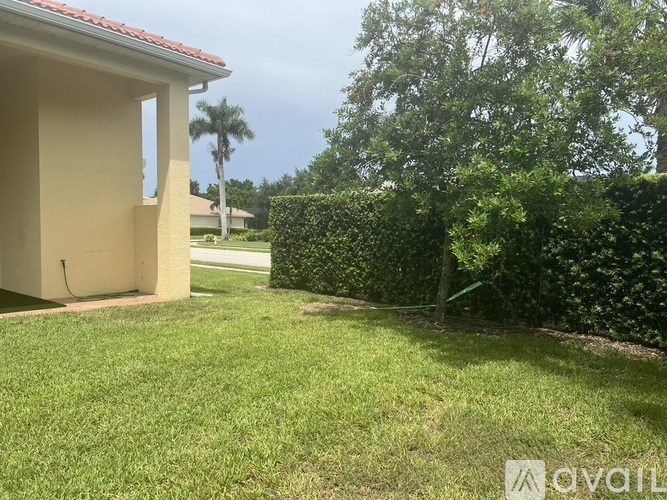A house with a red roof and a green lawn.