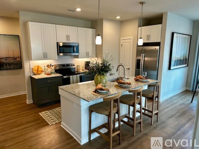 A kitchen with a table set for four with a vase of flowers in the middle.