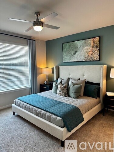 A bedroom with a large bed and a ceiling fan.