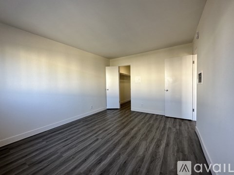 A room with wooden flooring and white walls.