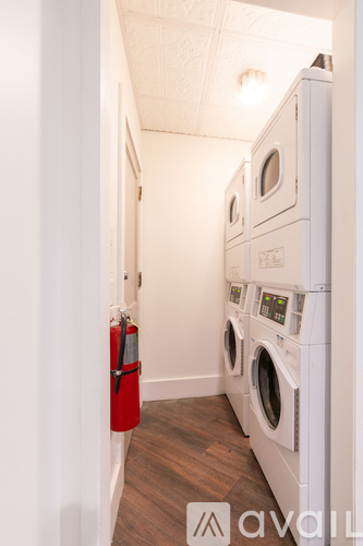 A row of white washing machines in a laundry room.