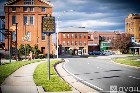A street view with a signpost in the foreground and a building with a clock tower in the background.