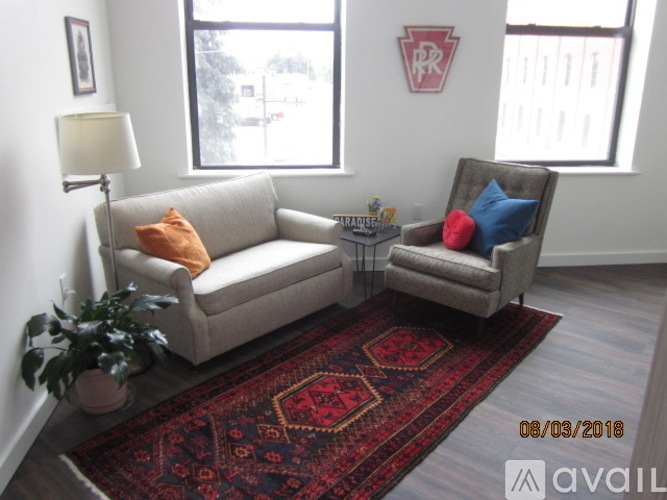 A living room with a couch, chair, and rug.