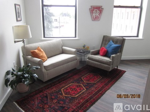 A living room with a couch, chair, and rug.