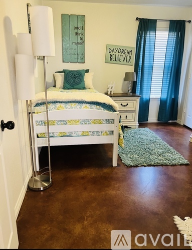 A bedroom with a bed, nightstand, and lamp.