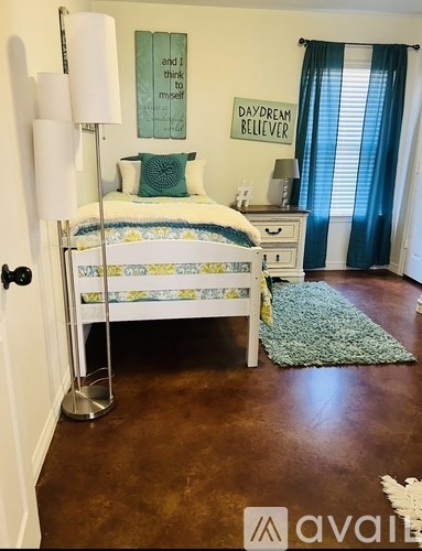 A bedroom with a bed, nightstand, and lamp.