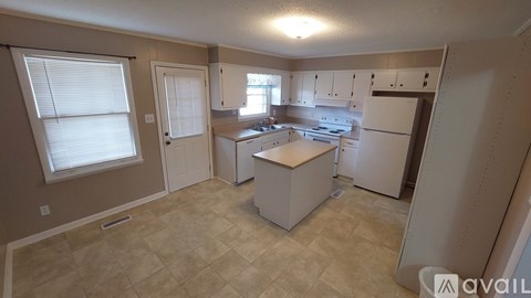 A kitchen with white appliances and cabinets is available for rent.
