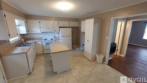 A kitchen with white cabinets and a wooden countertop.