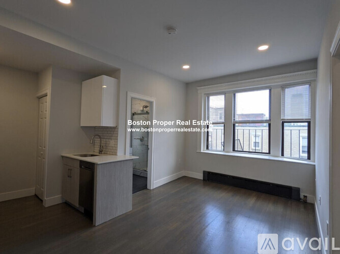 A kitchen area with a sink, cabinets, and a window.