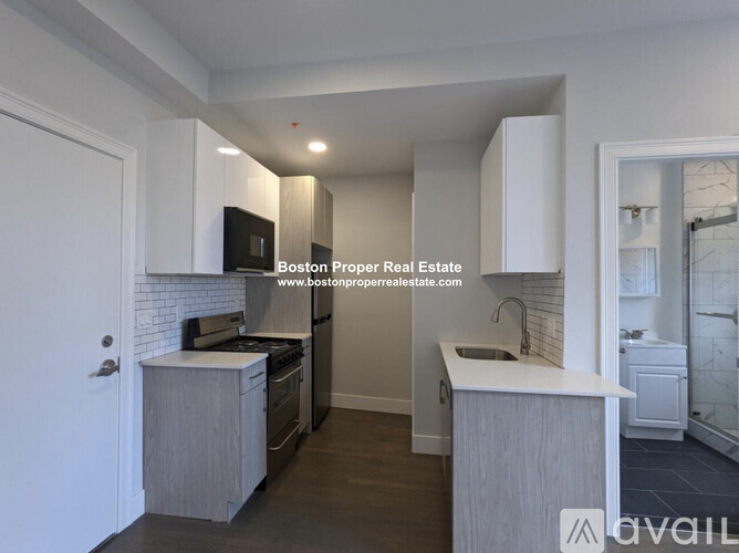 A modern kitchen with a white countertop and grey cabinets.