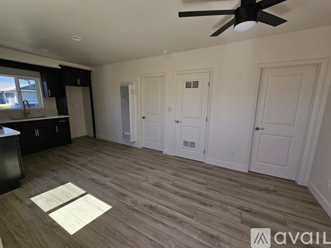 A room with a ceiling fan and wooden flooring.