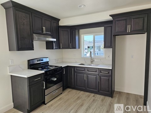 A kitchen with dark wood cabinets and a white countertop.