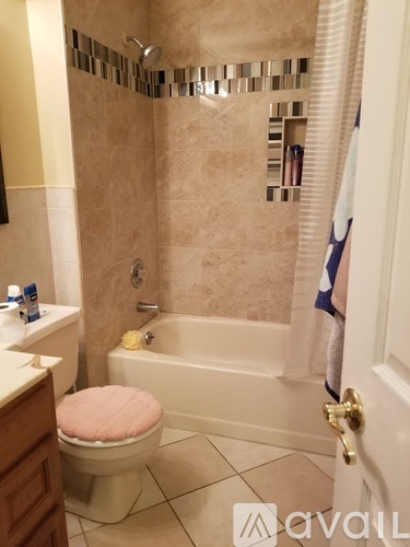 A bathroom with a pink toilet and a shower with a glass door.