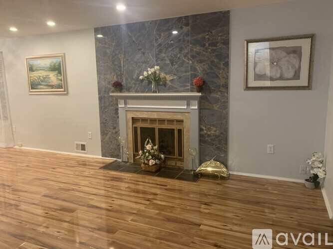 A living room with a fireplace and a painting on the wall.