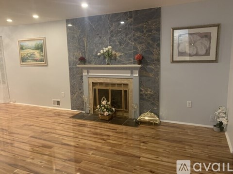 A living room with a fireplace and a painting on the wall.