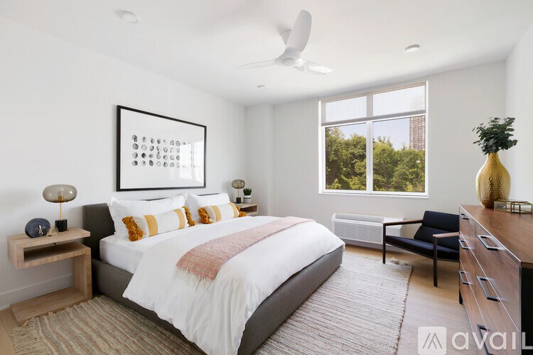 A bedroom with a large bed, a chair, and a painting on the wall.