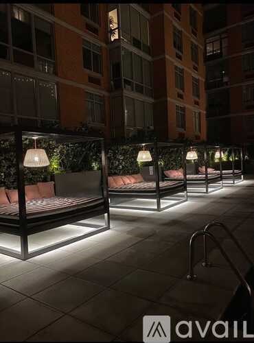 A row of benches with lamps on them are lit up at night.
