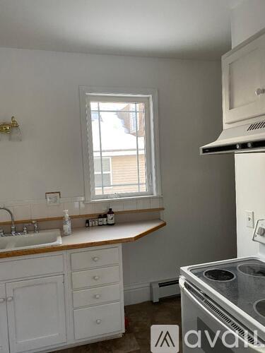 A kitchen with white cabinets and a window above the sink.