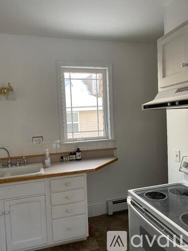 A kitchen with white cabinets and a window above the sink.