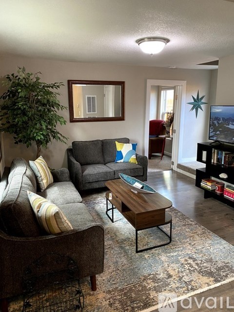 A living room with a grey couch and a brown chair.