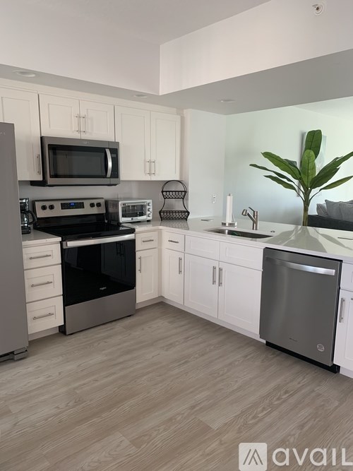 A kitchen with a wooden floor and white cabinets.