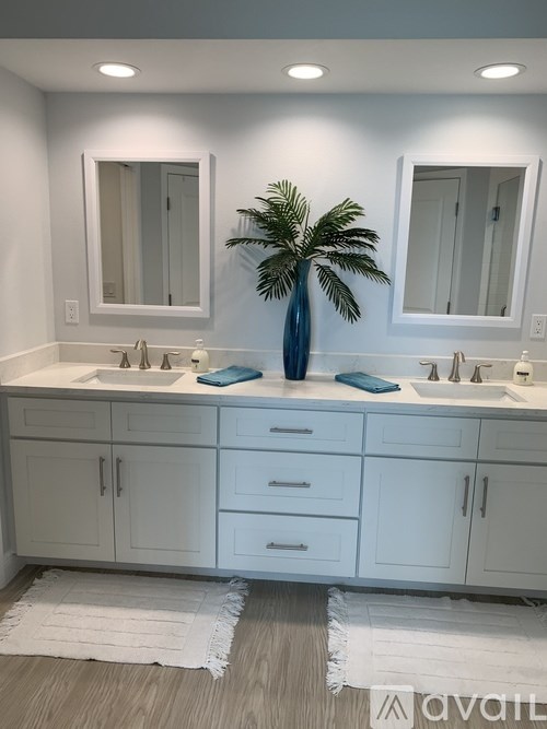 A bathroom with two sinks and a large mirror.