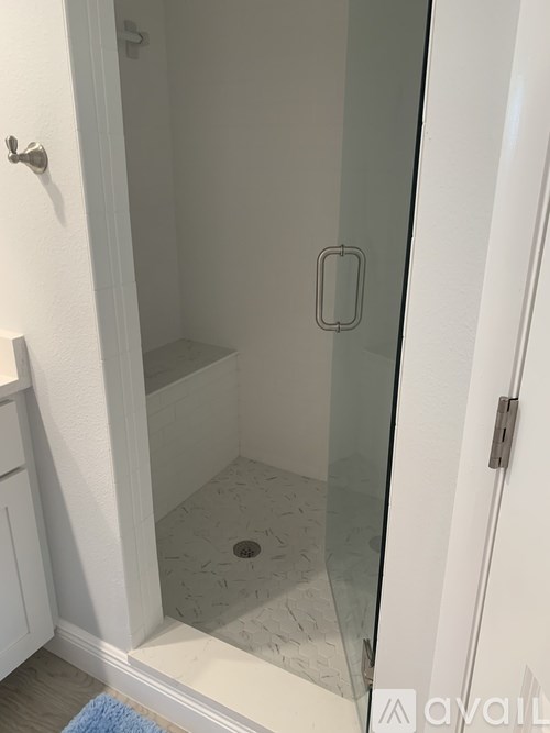 A white bathroom with a glass shower door.