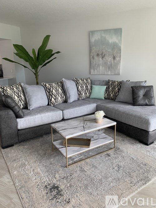 A grey couch with a coffee table in front of it.