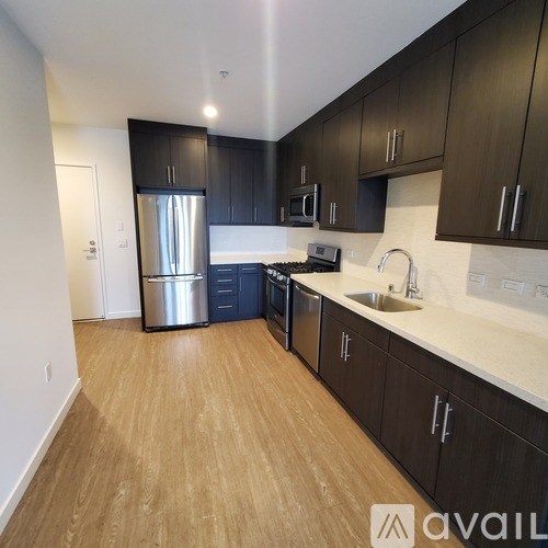 A kitchen with dark wood cabinets and a white countertop.