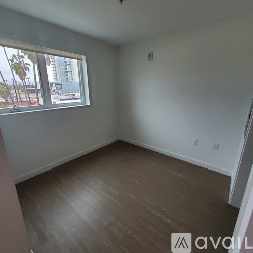 A room with a window and wooden flooring.